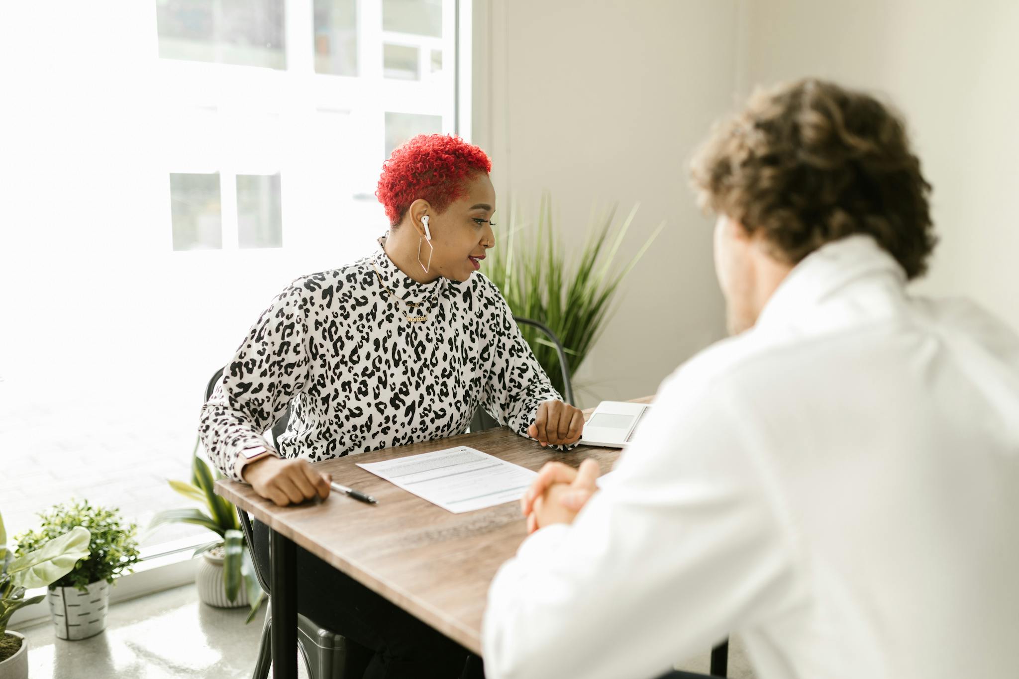 A business meeting with two people discussing documents in a bright office.
